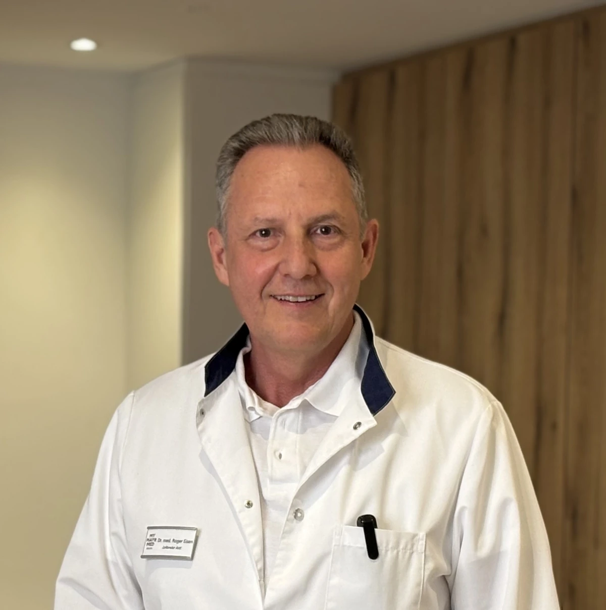Dr. med. Roger Eisen im weißen Arztkittel